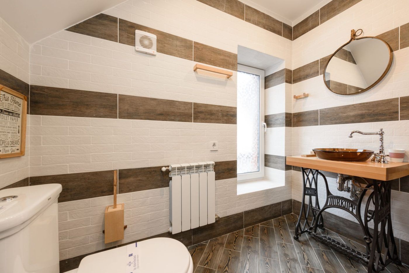 Сантехнік оглядає механізм зливного бачка унітазу у ванній кімнаті квартири, щоб усунути протікання води після змиву.